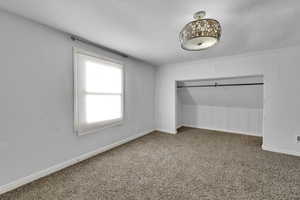 Unfurnished bedroom featuring carpet and a closet