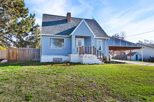 View of front facade featuring a chimney, stucco siding, roof with shingles, concrete driveway, and a carport