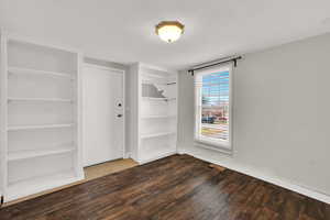 Unfurnished bedroom with a closet, wood finished floors, and a textured ceiling