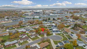 Aerial view of property and surrounding area with a mountainous background and nearby suburban area