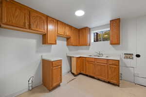Kitchen with light countertops, brown cabinets, light flooring, and wood walls