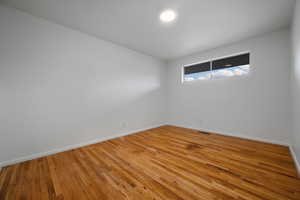 Unfurnished room featuring baseboards and wood finished floors
