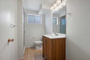 Full bathroom with light tile patterned flooring, a shower stall, and vanity