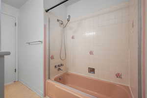 Bathroom featuring bathtub / shower combination and baseboards