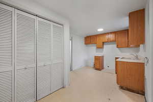 Kitchen with light countertops, brown cabinets, and recessed lighting