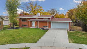 View of front of property featuring covered porch, brick siding, a front lawn, and concrete driveway
