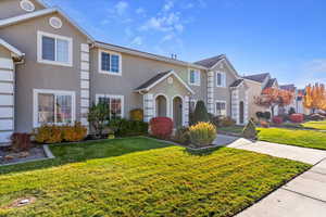 Traditional-style house featuring stucco siding and a front yard