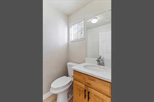 Half bathroom featuring vanity and toilet