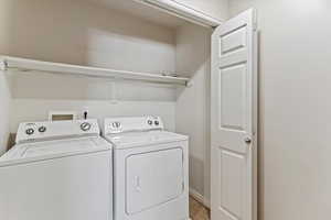 Laundry area with washer and clothes dryer and baseboards