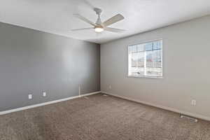 Spare room with carpet floors and a ceiling fan