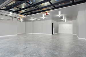 Garage with baseboards and a garage door opener