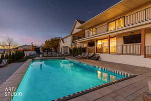 View of swimming pool featuring a patio and a balcony