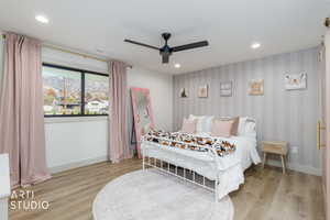 Bedroom featuring recessed lighting, a ceiling fan, light wood finished floors, wallpapered walls, and a mountain view