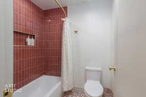 Full bath with shower / bathtub combination with curtain and toilet