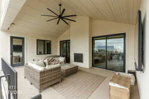 Balcony with ceiling fan, fireplace, and outdoor lounge area