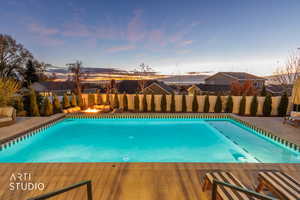 Pool at dusk with a patio and a fenced backyard