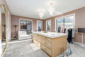 Spacious closet with a chandelier and carpet flooring
