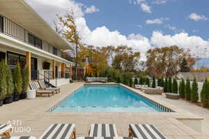 View of swimming pool with a patio area, a balcony, and an outdoor hangout area