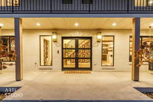 Doorway to property featuring brick siding and a patio