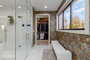 Bathroom featuring a walk in closet, wallpapered walls, a marble finish shower, and recessed lighting