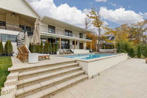View of swimming pool with a patio area, stairway, a ceiling fan, and a balcony