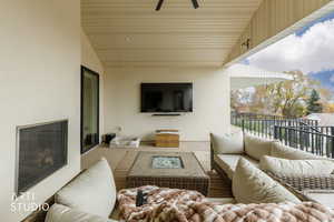 Balcony with an outdoor living space with a fire pit and a ceiling fan