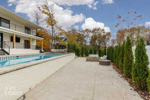 Outdoor pool with a patio, an outdoor living space, a balcony, and a fenced backyard