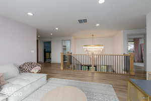 Living room featuring recessed lighting, wood finished floors, and a chandelier