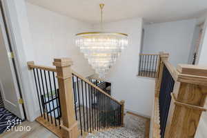 Staircase featuring a chandelier and wood finished floors