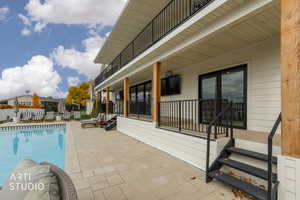 View of swimming pool featuring a patio area and a balcony