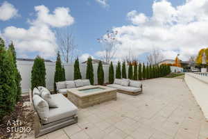 Fenced backyard featuring an outdoor living space with a fire pit and a patio