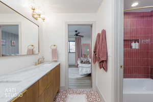 Full bathroom featuring ensuite bathroom, double vanity, tub / shower combination, tile patterned floors, and ceiling fan