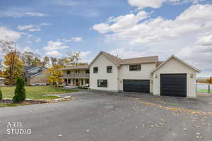 View of front of home featuring driveway, 6 car garage, and a front lawn