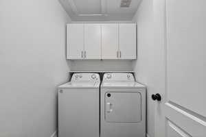 Laundry area with cabinet space and washer and clothes dryer