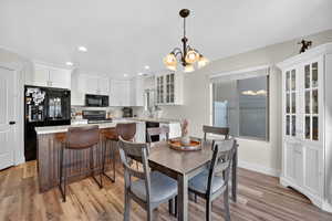 Dining area with light wood-type flooring, recessed lighting, and a chandelier