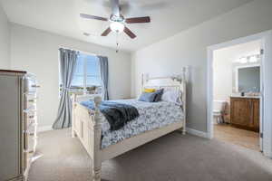 Bedroom with light carpet, ceiling fan, and ensuite bathroom