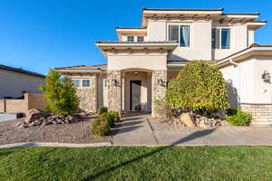 View of front facade with stucco siding and stone siding