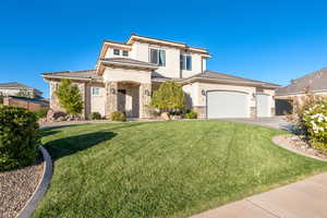View of front of home with stucco siding, stone siding, and a garage