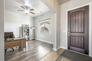 Entryway featuring arched walkways, ceiling fan, and light wood-type flooring