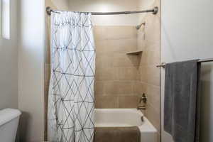 Full bathroom featuring shower / bath combo with shower curtain and toilet