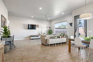 Living area featuring a ceiling fan, recessed lighting, and light tile patterned flooring