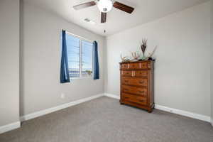 Carpeted bedroom featuring baseboards and a ceiling fan