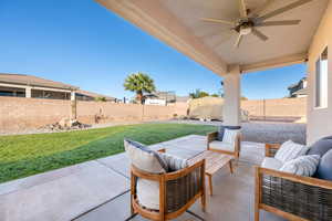 Fenced backyard with a patio area, a ceiling fan, and an outdoor living space