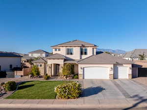 View of front facade featuring an attached garage, stone siding, stucco siding, and concrete driveway