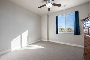 Spare room featuring light colored carpet and ceiling fan