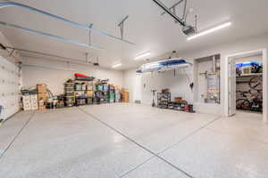 Garage with strapped water heater and a garage door opener