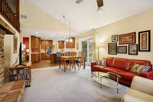 Living room featuring light carpet, high vaulted ceiling, ceiling fan, and recessed lighting