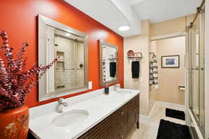 Full bath with a shower stall and double vanity