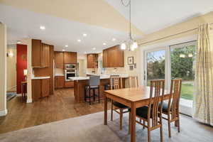 Dining area with recessed lighting, dark wood finished floors, vaulted ceiling, and a chandelier