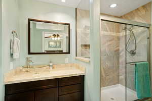 Full bathroom featuring a shower stall and vanity
